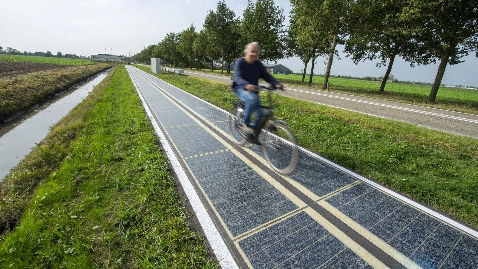 Route équipée de dalles solaires empruntée par un cycliste